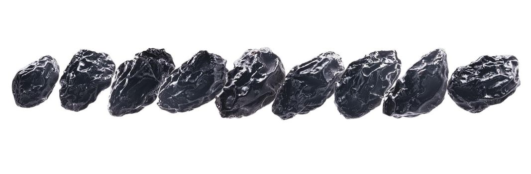 Dried prunes levitate on a white background