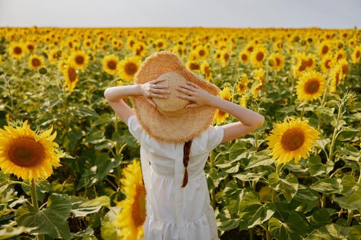 woman with hat sunflower field summer freedom landscape. High quality photo