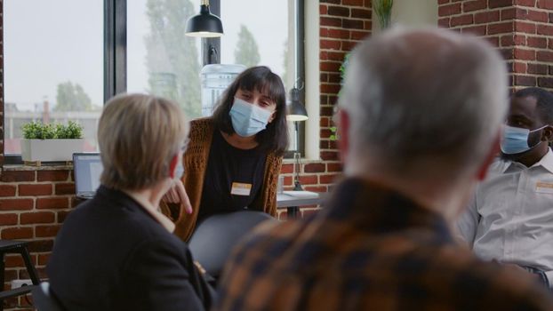 Desperate woman with face mask explaining anger management issues to therapist at aa meeting