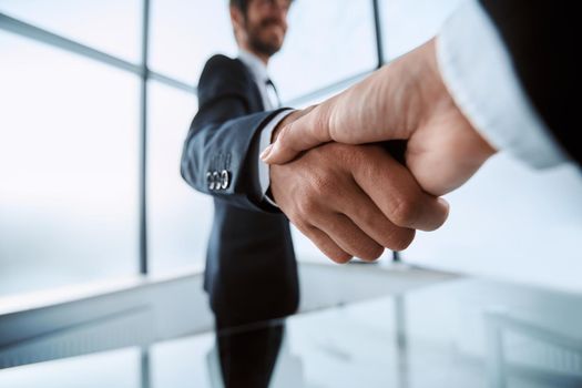 image is a confident handshake of business partners.