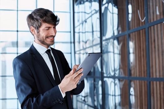 smiling businessman using a digital tablet in the office.