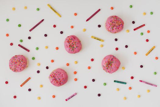 holiday, birthday party composition with colorful pink glazed donuts on white 