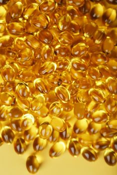 Golden capsules of Vitamin Omega 3 Fish Oil close-up
