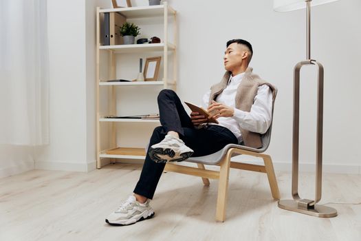 handsome man with a tablet sits in a chair communication interior