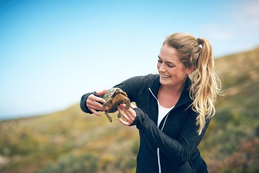 My new little friend I found. Shot of a young woman holding a tortoise outdoors.