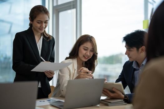 Diverse business workgroup designers team with asian woman leader discuss paperwork financial report statistical data, forecasting working on common project. Brainstorm, briefing activity concept