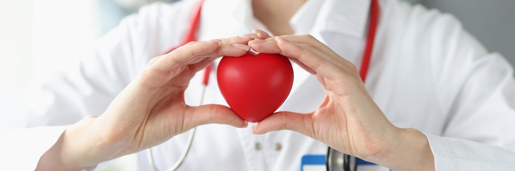 Close-up of cardiologist holding heart in hands