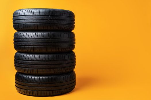 Car tires isolated on yellow background, close up