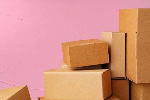 Set of cardboard boxes on pink background