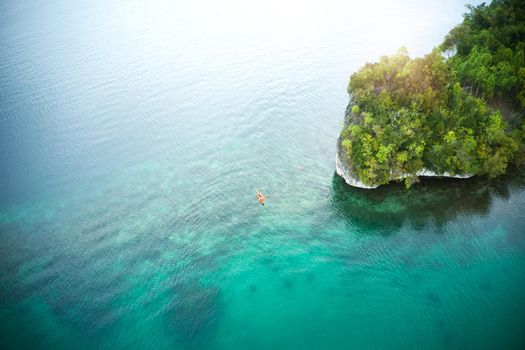 This is a once in life time experience. High angle shot of an adventurous young couple canoeing together in the beautiful oceans of Indonesia.