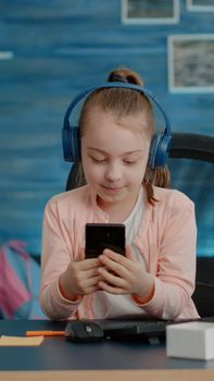 Schoolgirl using video call on smartphone for school courses