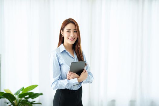 Entrepreneur, Business Owner, Accountant, Portrait of Starting small businesses Asians holding a smiling tablet in the office.