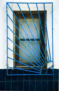 Blue wooden window with geometric iron lattice