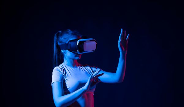 Portrait of female architector wearing virtual reality headset and making gestures with hands, she uses VR technology for industrial design, development, architecting.