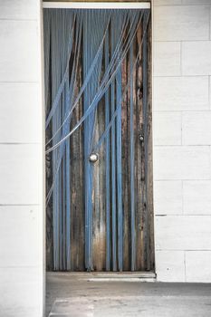 Wooden door with striped plastic curtain