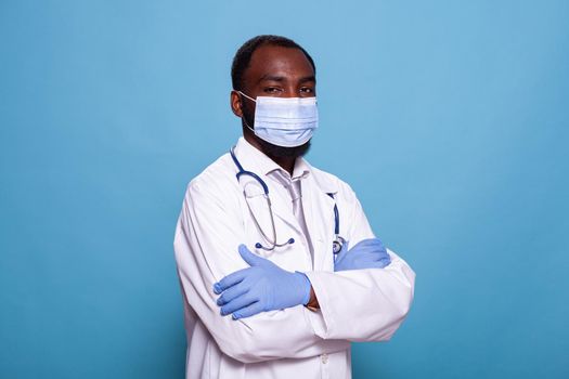 Portrait of confident doctor wearing scrubs with face mask and latex gloves