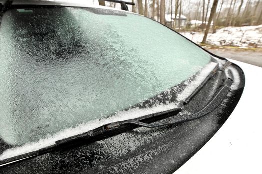 Freezing Rain Creates a Layer of Ice and Coats a Passenger Vehicle. Close up of Windshield