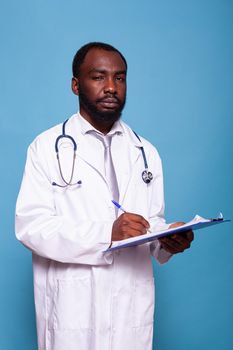 Portrait of overconfident doctor looking at camera holding clipboard