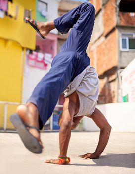 Street style. Low angle shot of a young male breakdancer in an urban setting.