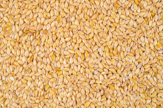 Gold flax seeds texture as background.