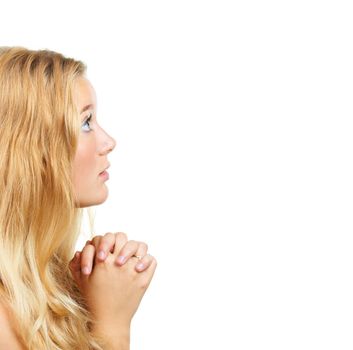 Searching for guidance from above. Shot of an attractive young woman praying against a white background.