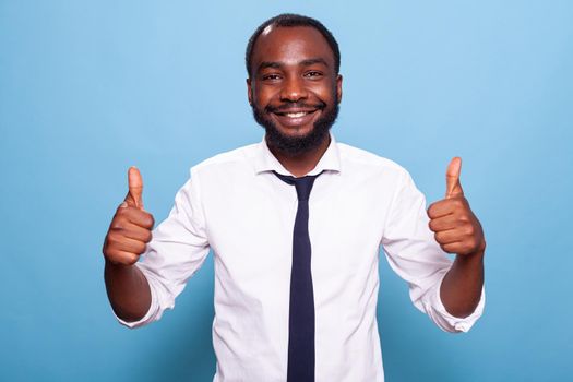 Portratit of smiling optimistic person in white shirt giving two thumbs up
