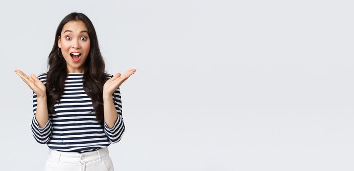 Lifestyle, people emotions and casual concept. Surprised excited asian woman found out awesome big news, clap hands amazed and gasping wondered, standing white background