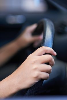 Steering in the right direction. Shot of hands holding onto a steering wheel while driving.