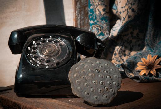 Fresh green lotus seed pods with Old black retro rotary Telephone. Selective focus.