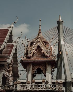 Bangkok, Thailand. Mar - 12, 2022 : Beautiful view of Buddhist thai temple with suspension bridge background can coexist perfectly. No focus, specifically.