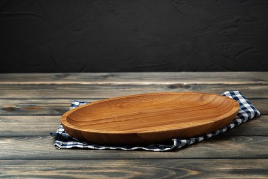 Wooden board with kitchen napkin on dark wooden table