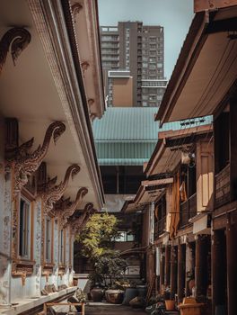 Bangkok, Thailand. Mar - 12, 2022 : The path between The ordination hall and Living quarters of the monks with modern tall buildings in the background. Perfectly coexist. Selective focus.