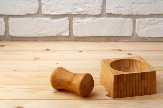 Wooden mortar with pestle on wooden background