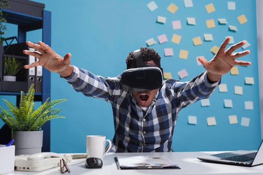 Expressive amazed african american company office employee enjoying virtual reality gaming technology.