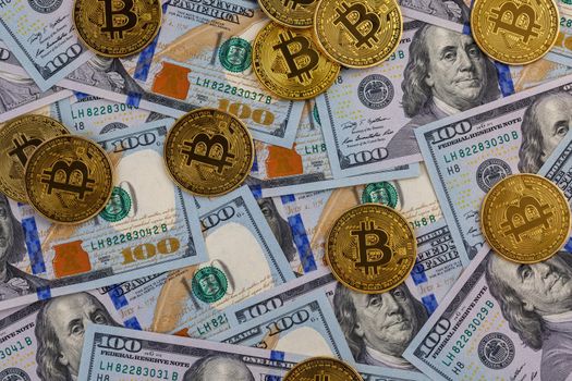 yellow bitcoin coins scattered over US dollar paper banknotes