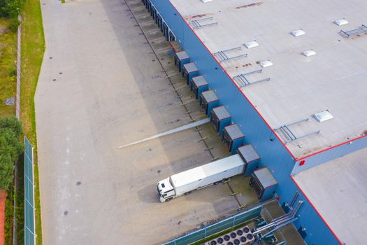 Aerial view of goods warehouse. Logistics center in industrial city zone from drone view.