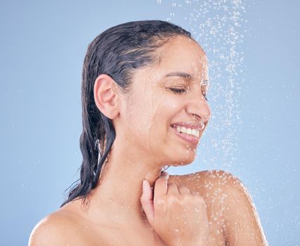Happiness is just a shower away. Shot of a beautiful young woman taking a shower against a blue background.