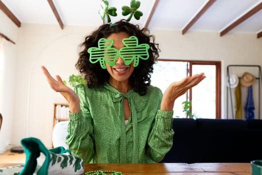 Caucasian woman dressed in green with shamrock glasses making st patrick's day video call