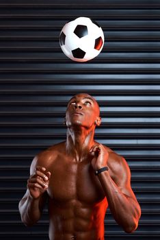Im headed straight to the top. Studio shot of an athletic young man playing with a soccer ball against a grey background.