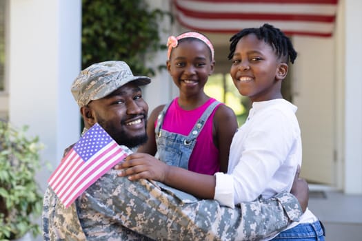 African american soldier father greeting smiling son and daughter in front of house. soldier returning home to family.