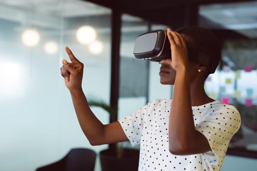 Smiling african american woman using vr headset at work