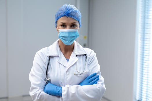 Portrait of caucasian female doctor wearing mask and latex gloves