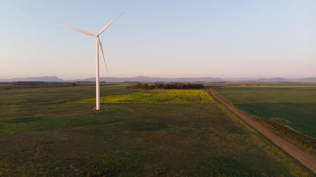 General view of wind turbine in countryside landscape with cloudless sky
