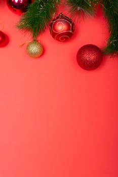 Composition of garland with baubles and copy space on red background