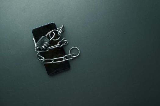 Smart Phone With Padlock And Chain Over black Background.