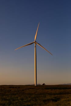 General view of wind turbine in countryside landscape during sunset