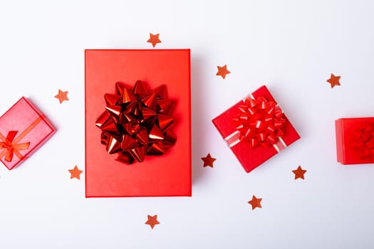 Composition of red christmas presents and stars on white background