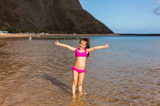 Cute little girl playing on sandy beach Tenerife, Canary Islands
