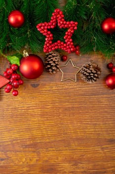 Composition of christmas decorations with fir tree, baubles and copy space on wooden background. christmas, tradition and celebration concept.