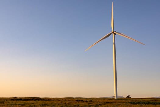 General view of wind turbine in countryside landscape during sunset